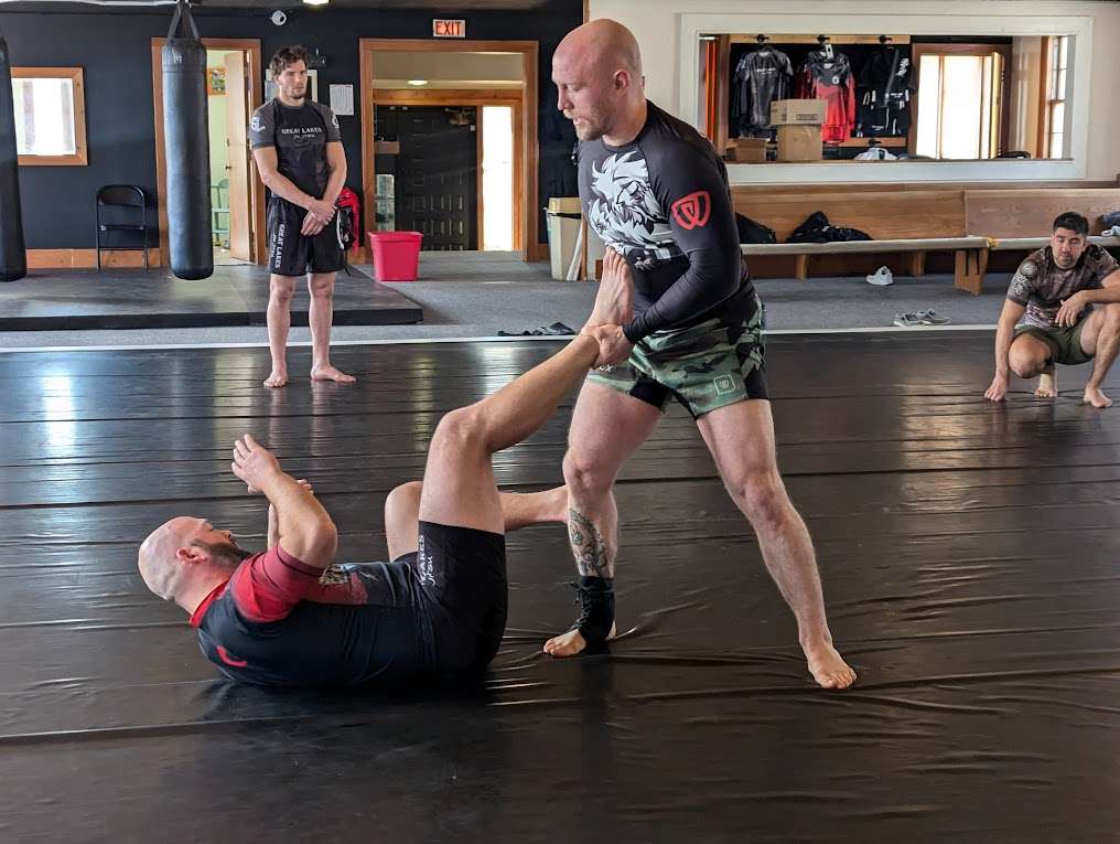 Adult students practicing jiu-jitsu together during a group class at Great Lakes BJJ in Flint